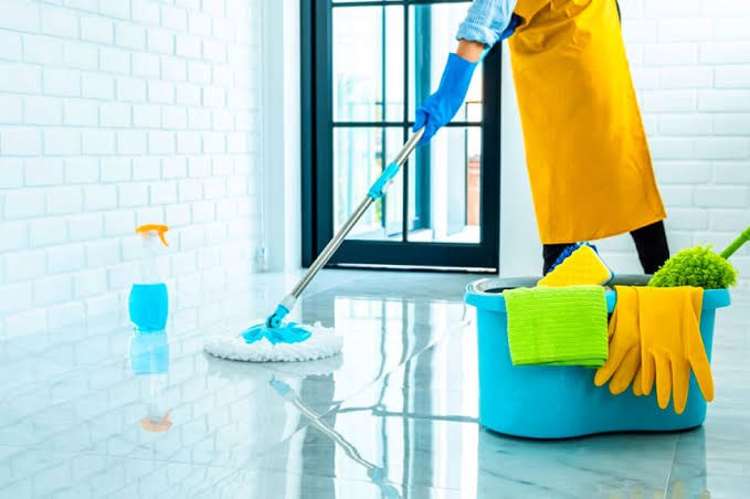Mopa, balde y guantes sobre un piso recién limpiado